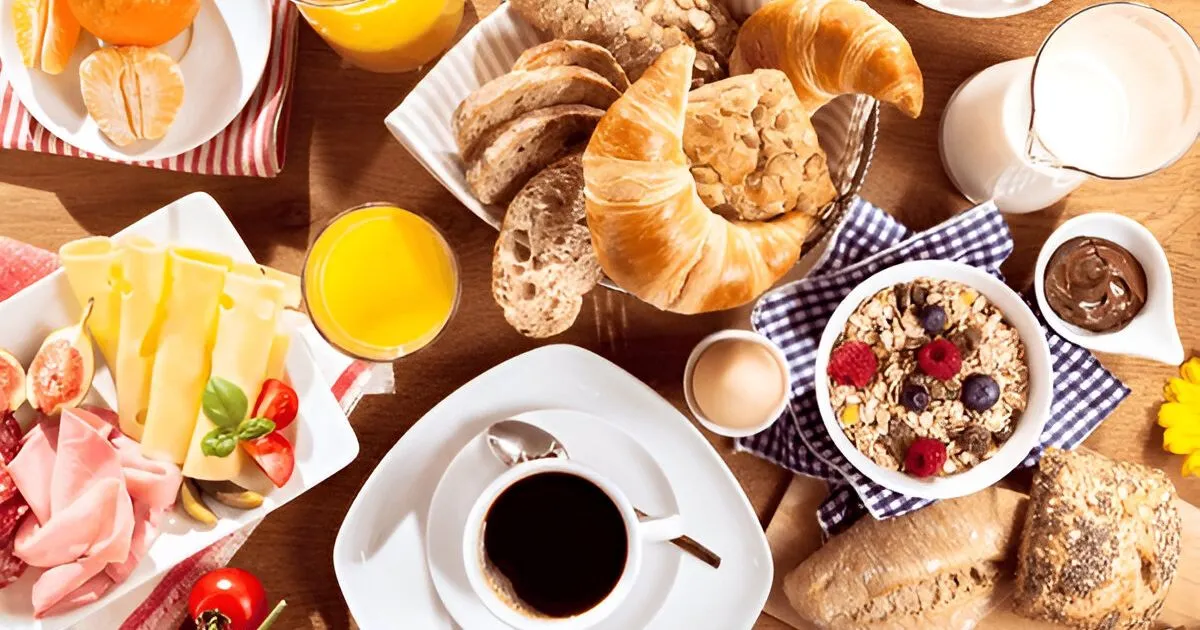 A delicious quick breakfast with a croissant, scrambled eggs, fresh fruit, and a steaming cup of coffee on a cozy café table.